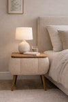 Angled view of the beige Lina upholstered bedside table showing tapered legs - Sohowells