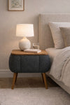 Angled view of the grey Lina upholstered bedside table showing tapered wooden legs - Sohowells
