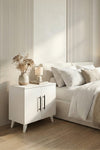 White Lumen bedside table styled with a lamp and books on the open shelf
